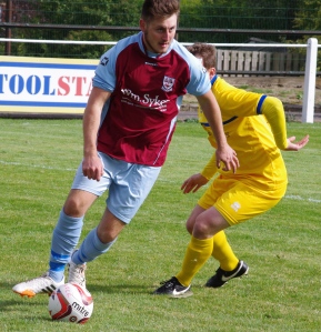 AFC Emley substitute Nathan Perks holds up the ball 