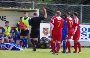 The referee Daniel Bennett doesn't even look at Selby midfielder Nathan Kamara as he shows the red card